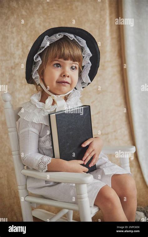 Retro portrait of beautiful child in a rocking chair with book Stock ...