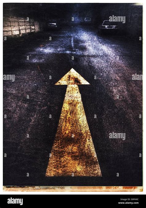 Yellow arrow one way sign on road Stock Photo - Alamy