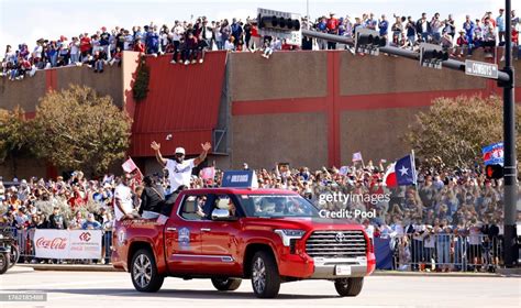 Adolis Garcia of the Texas Rangers waves to fans lining the streets ...