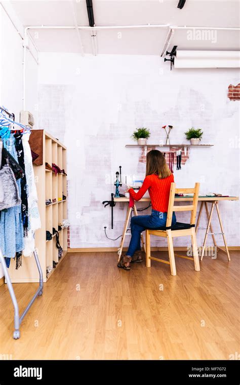 Fashion designer in studio using sewing machine Stock Photo - Alamy