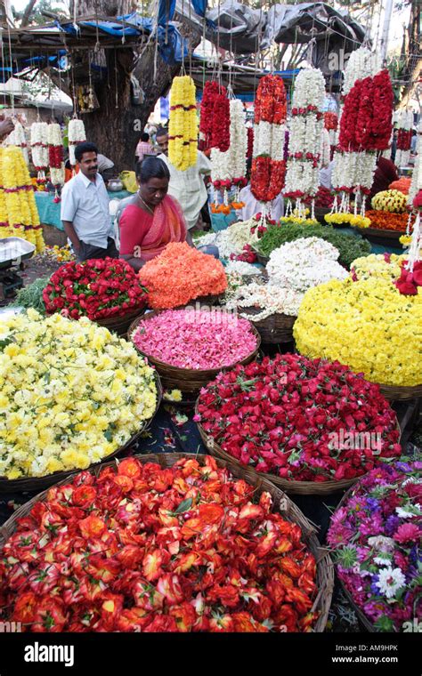 A colourful flower stall at the Gandhi Bazaar in Bangalore, India, with baskets of boldly ...