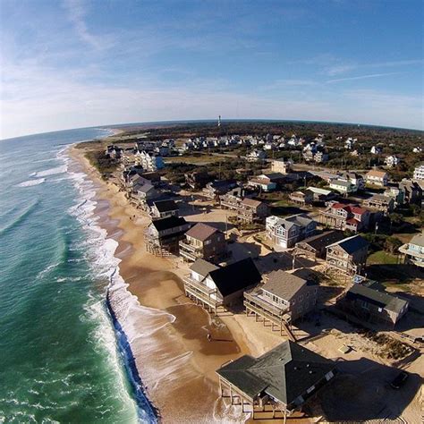 an aerial view of the beach and ocean with houses on it's shore line