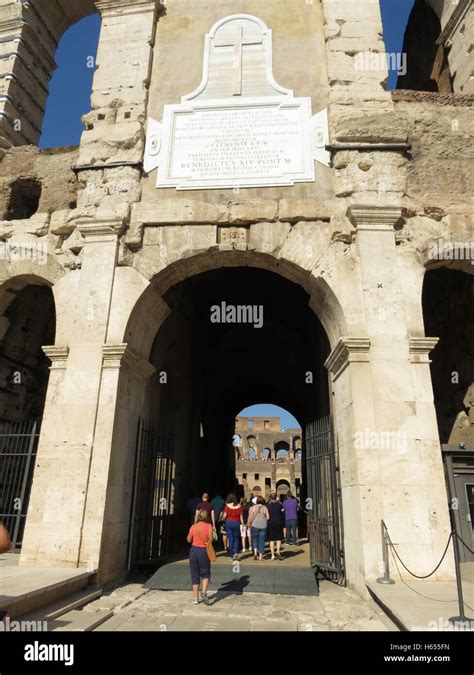 The main entrance to the Colosseum with tourists walking through ...