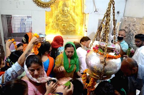 Hindu devotees perform rituals pouring milk and water on a Shiva Lingam ...