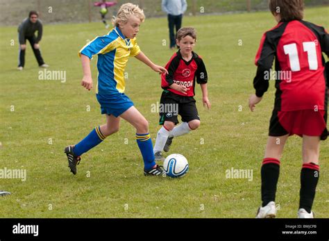 Three young kids children teenage boys playing football soccer game sports UK Stock Photo - Alamy