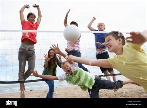 Teenagers playing volleyball Stock Photo - Alamy