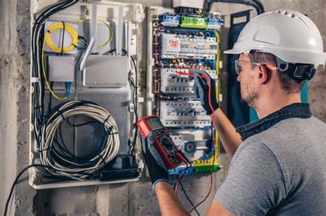 Free Photo | Man an electrical technician working in a switchboard with fuses