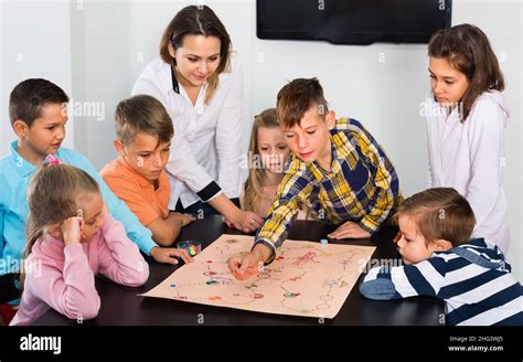 Boys and little girls playing at board game Stock Photo - Alamy