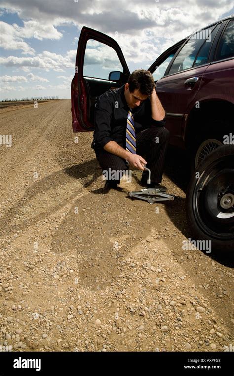 Man changing flat tire Stock Photo - Alamy