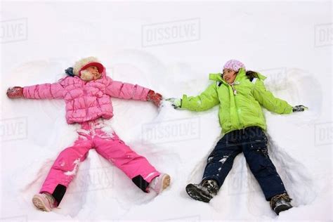 Children Making Snow Angels - Stock Photo - Dissolve