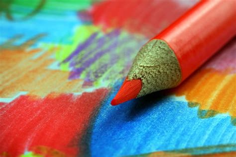 Premium Photo | A red pencil with a red tip sits on a colorful table.