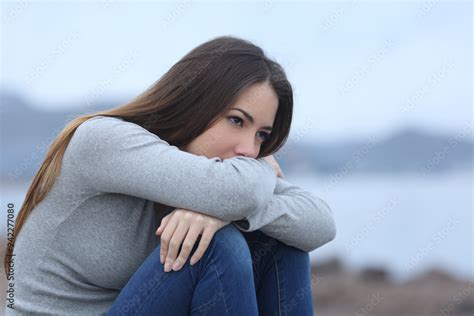 Sad girl looking away alone on the beach Stock Photo | Adobe Stock