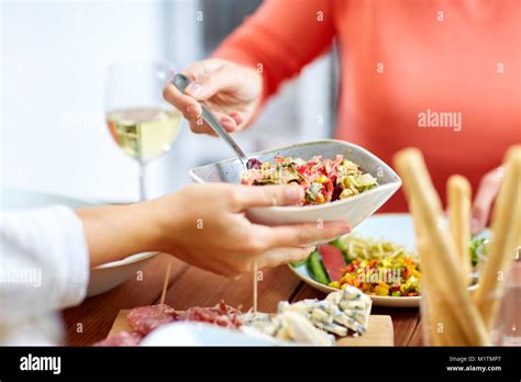 people eating salad at table with food Stock Photo - Alamy