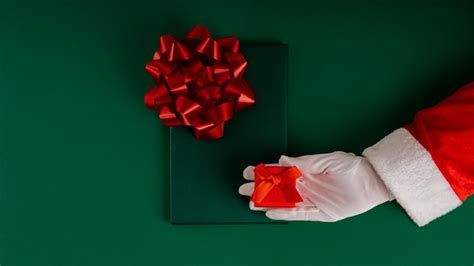 Premium Photo | Cropped santa claus hands holding christmas gift