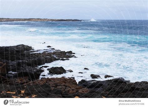 Ocean view landscape with strong waves and rocky landscape. Blue color ...