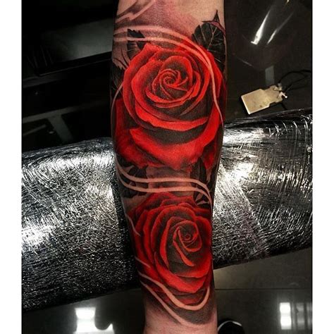 a red and black rose tattoo on the arm