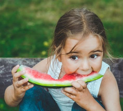 Premium Photo | Child eating watermelon in the garden. Kids eat fruit ...