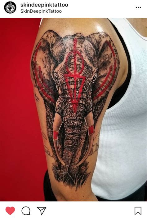 an elephant tattoo on the right arm and shoulder, with red lines coming out of its trunk