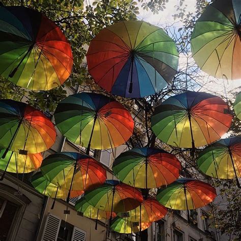 many multicolored umbrellas are hanging in the air