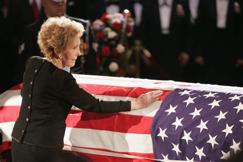 Mrs. Reagan touches the coffin of her husband during his state funeral on Capitol Hill on June 9 ...