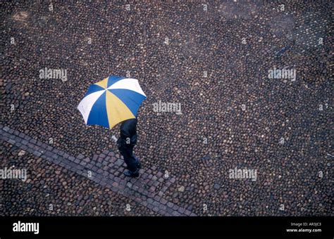 Man walking in rain with umbrella Stock Photo - Alamy