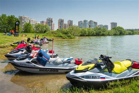 BRP Sea-Doo Jet Ski Watercrafts Rest by Lake Bank on Sunny Day on City Building Background ...