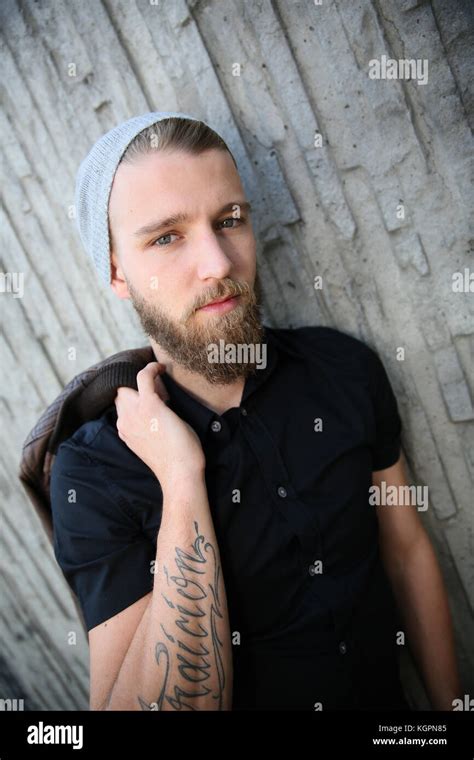 Stylish guy leaning on concrete wall in street Stock Photo - Alamy