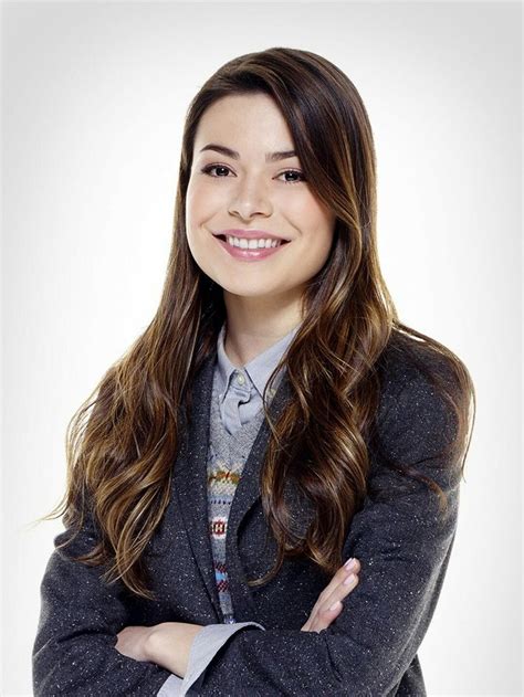 a woman with her arms crossed smiling at the camera