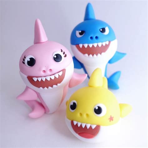 three plastic toys that look like sharks with big eyes and sharp teeth are sitting next to each ...