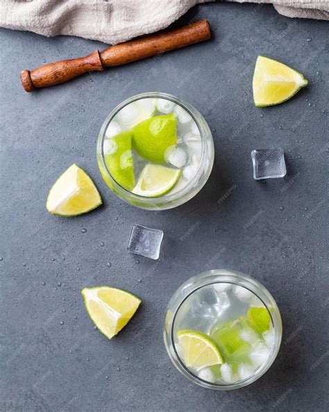 Premium Photo | Brazilian lemon caipirinha in glasses with ice and fruit slices over stone ...