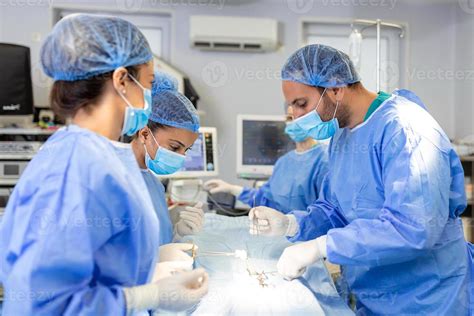 Surgical team performing surgery in modern operation theater,Team of doctors concentrating on a ...