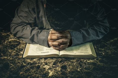 Man praying to God on an open Bible | High-Quality Stock Photos ~ Creative Market