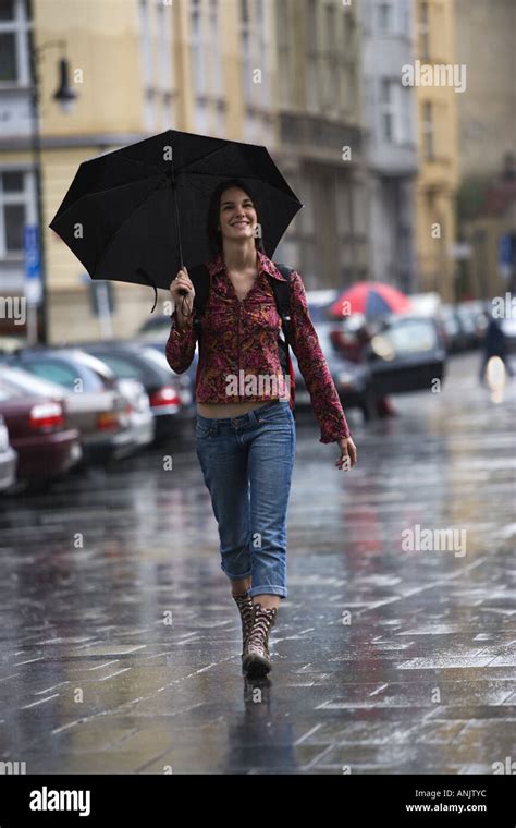 Teenage girl walking in the rain with an umbrella Stock Photo: 8882363 - Alamy