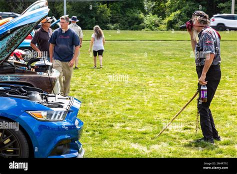 A blue late model Ford Mustang in line with cars being photographed at ...