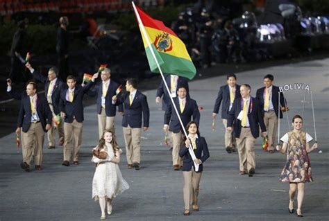 Bolivia's Karen Milenka Torrez Guzman holds the national flag as she leads the contingent in the ...