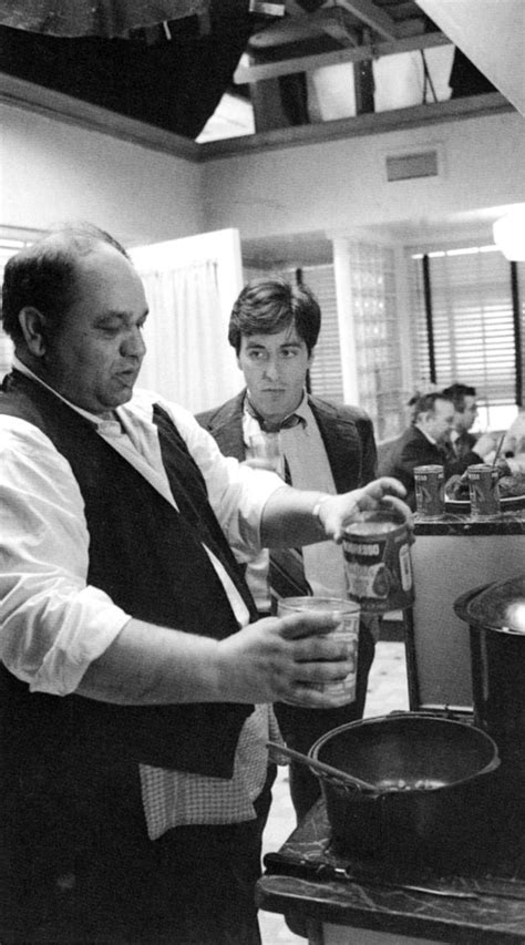 black and white photograph of two men in a kitchen with one holding a ...