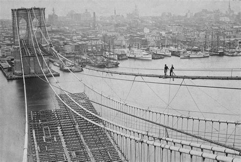 Two men standing on a catwalk surveying the construction of the ...