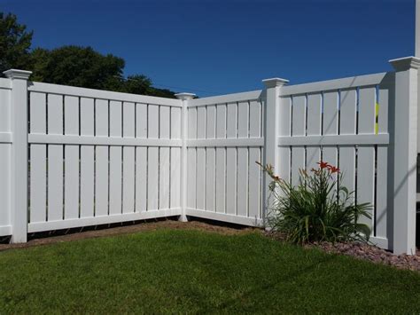 a white picket fence with flowers in the foreground