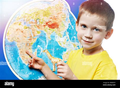 Niño pequeño con jirafa de juguete muestra África en el mapa del mundo Fotografía de stock - Alamy