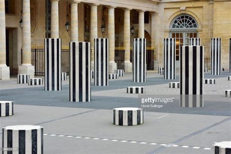 many black and white striped poles in front of a building with columns ...