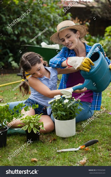 Daughter Assisting Mother Watering Potted Plants Stock Photo 679592509 ...