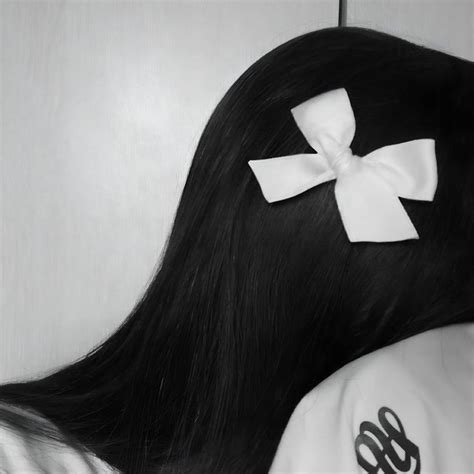 the back of a woman's head with a white bow in her long hair