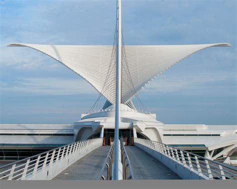 a large white building with a long metal walkway