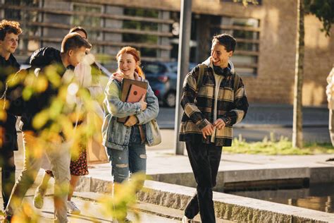 Group of friends walking outside college. Students walking together after class in high school ...