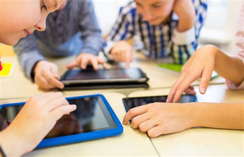 487093020 | close up of school kids playing with tablet pc | verkeorg ...