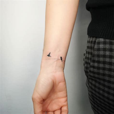 Tiny Birds on Wrist Tattoo by Michał Sukiennik