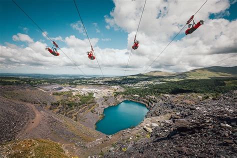 two people on skis are suspended above the ground by wires over a body ...