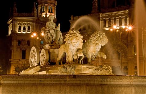 a fountain in front of a large building at night