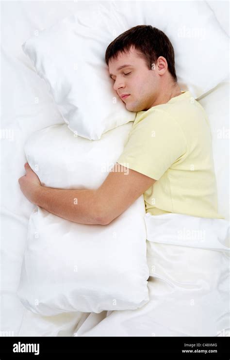 Photo of handsome man sleeping and holding soft white pillow Stock ...