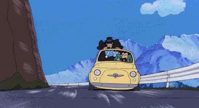 a yellow car driving down a road with mountains in the background